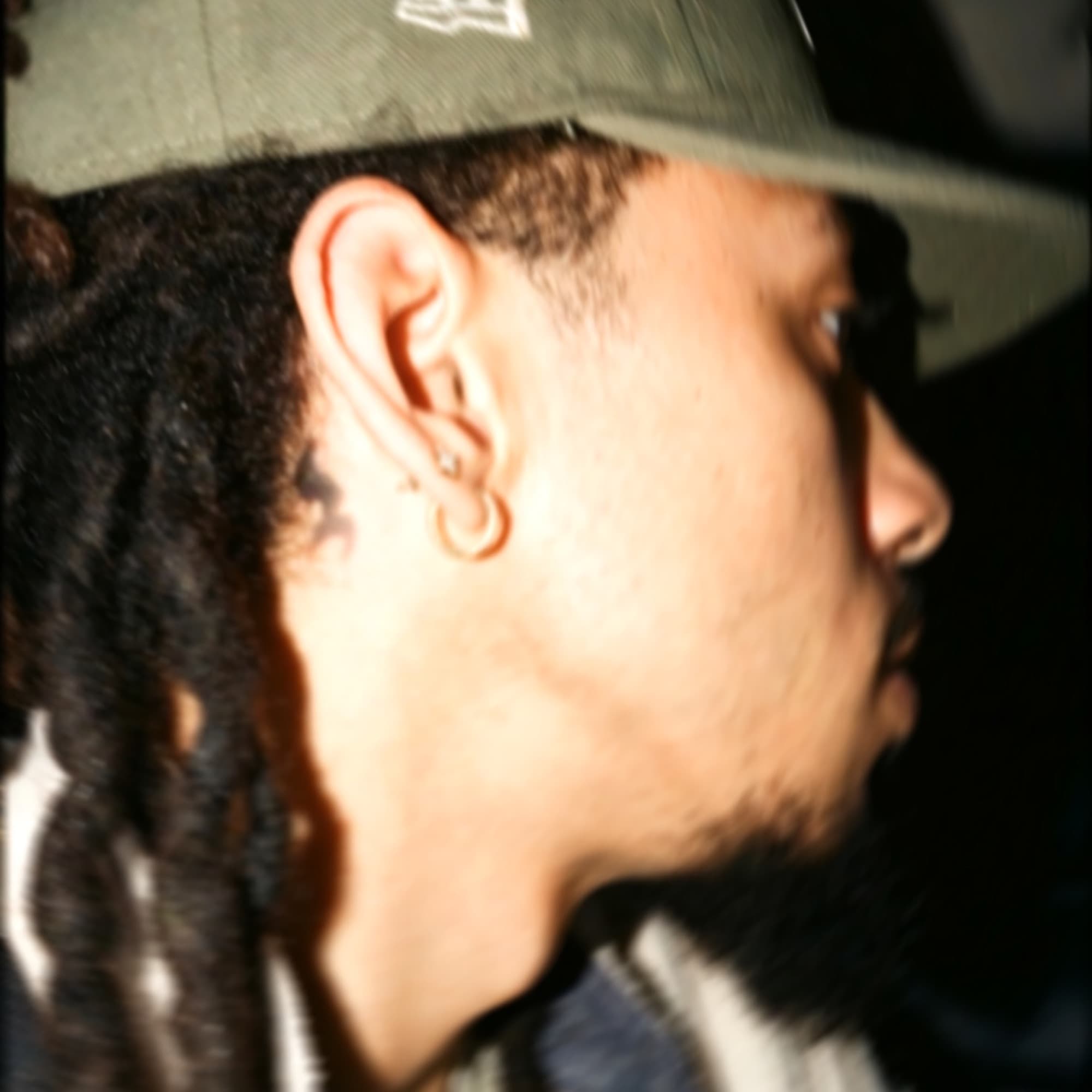 Close profile portrait of Bubba 3ig in an olive cap